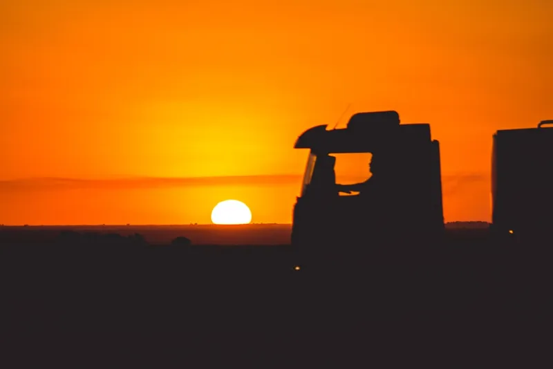 Silhueta de caminhão na estrada ao pôr do sol